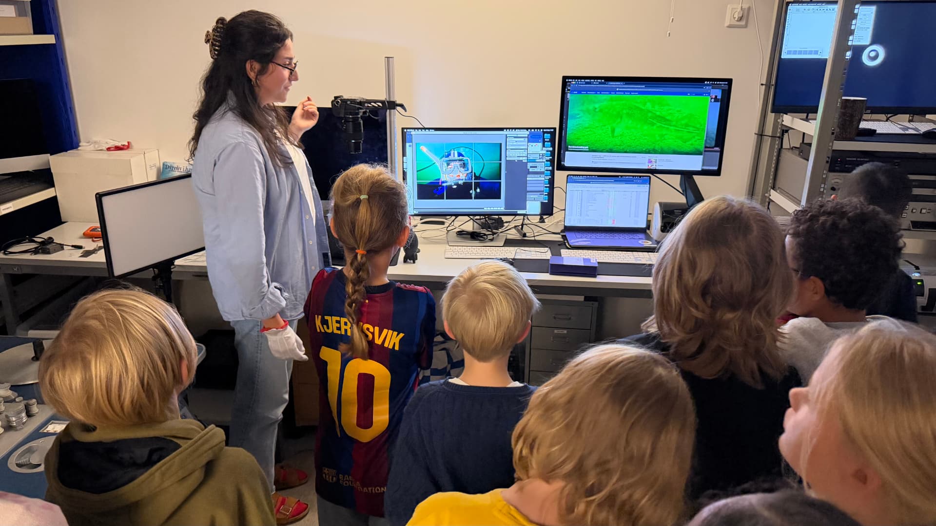 An Ocean Archive archivist shows students from Kungsholmens Friskola how a photographic slide is digitised