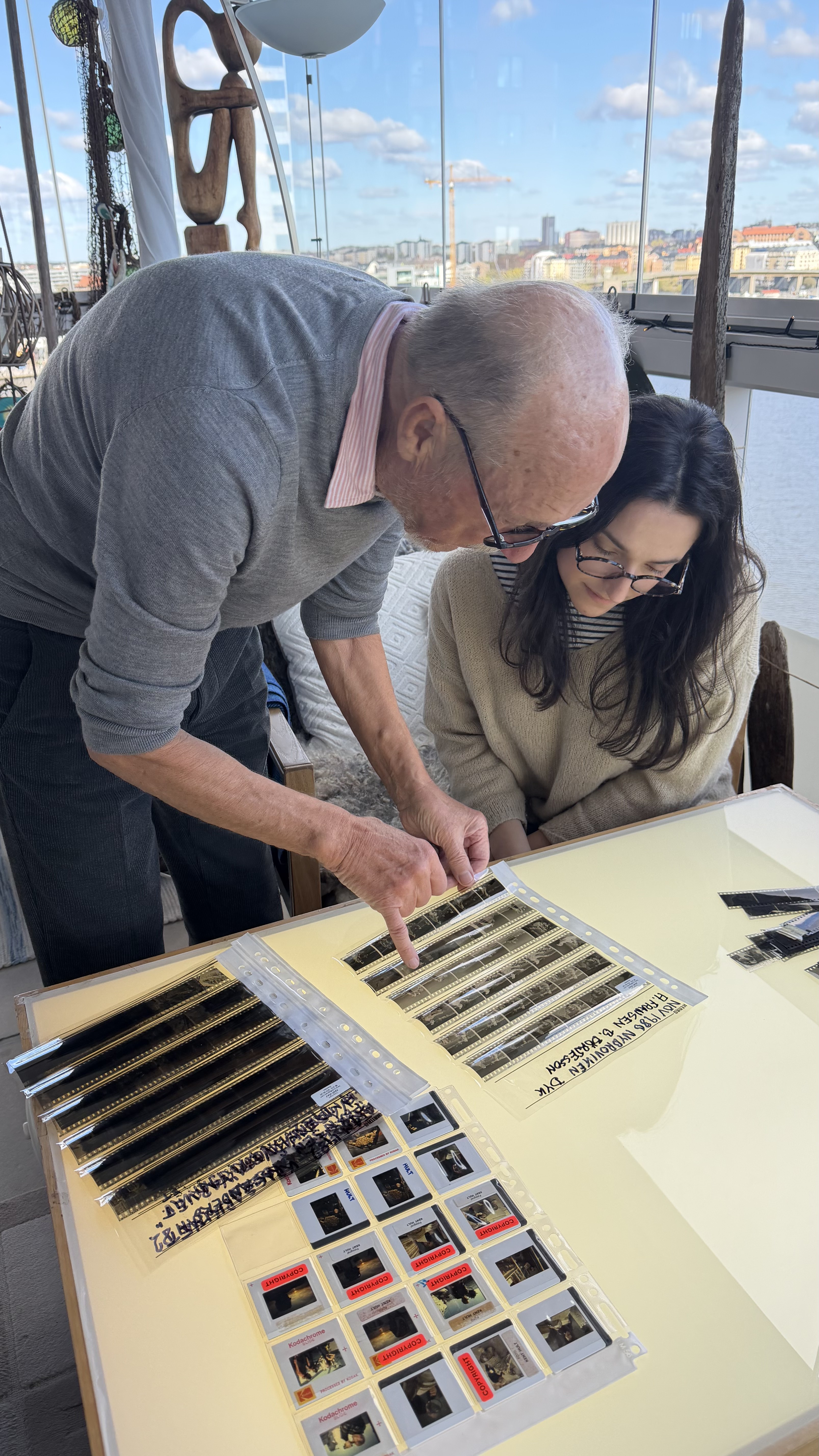 Kent Hult and Ocean Archive's archivist Jeanne-Alice reviewing original film strips on the light table.