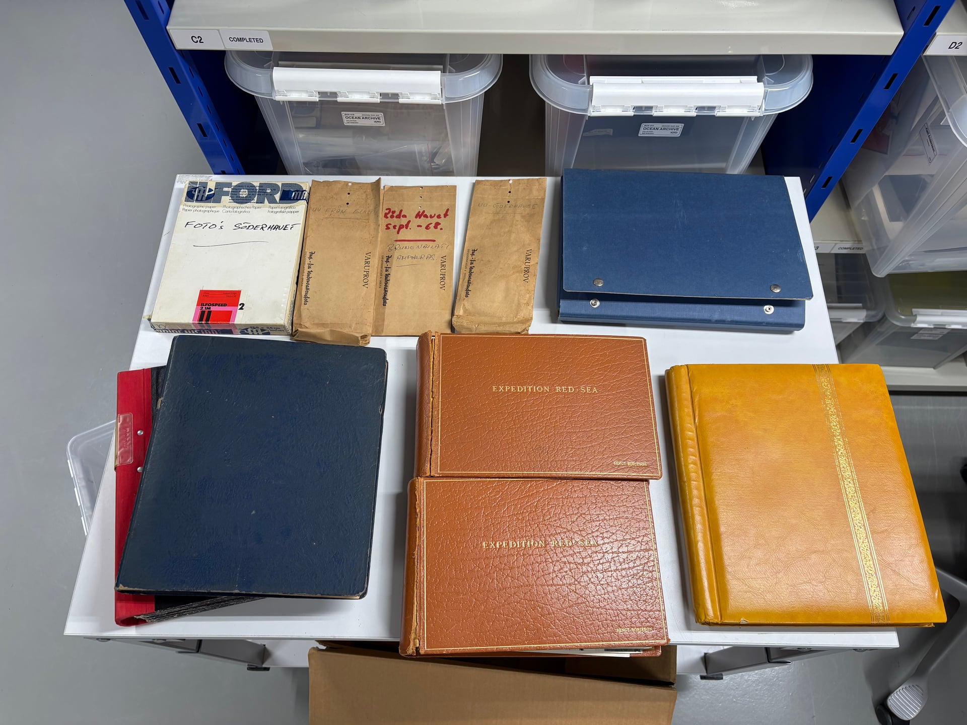 Original photo albums and envelopes from the Bengt Börjeson collection, including two leather-bound 'Expedition Red Sea' albums.